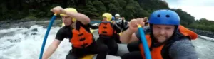 A group of men white water rafting.