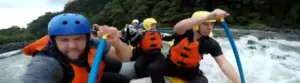 A group of men white water rafting.
